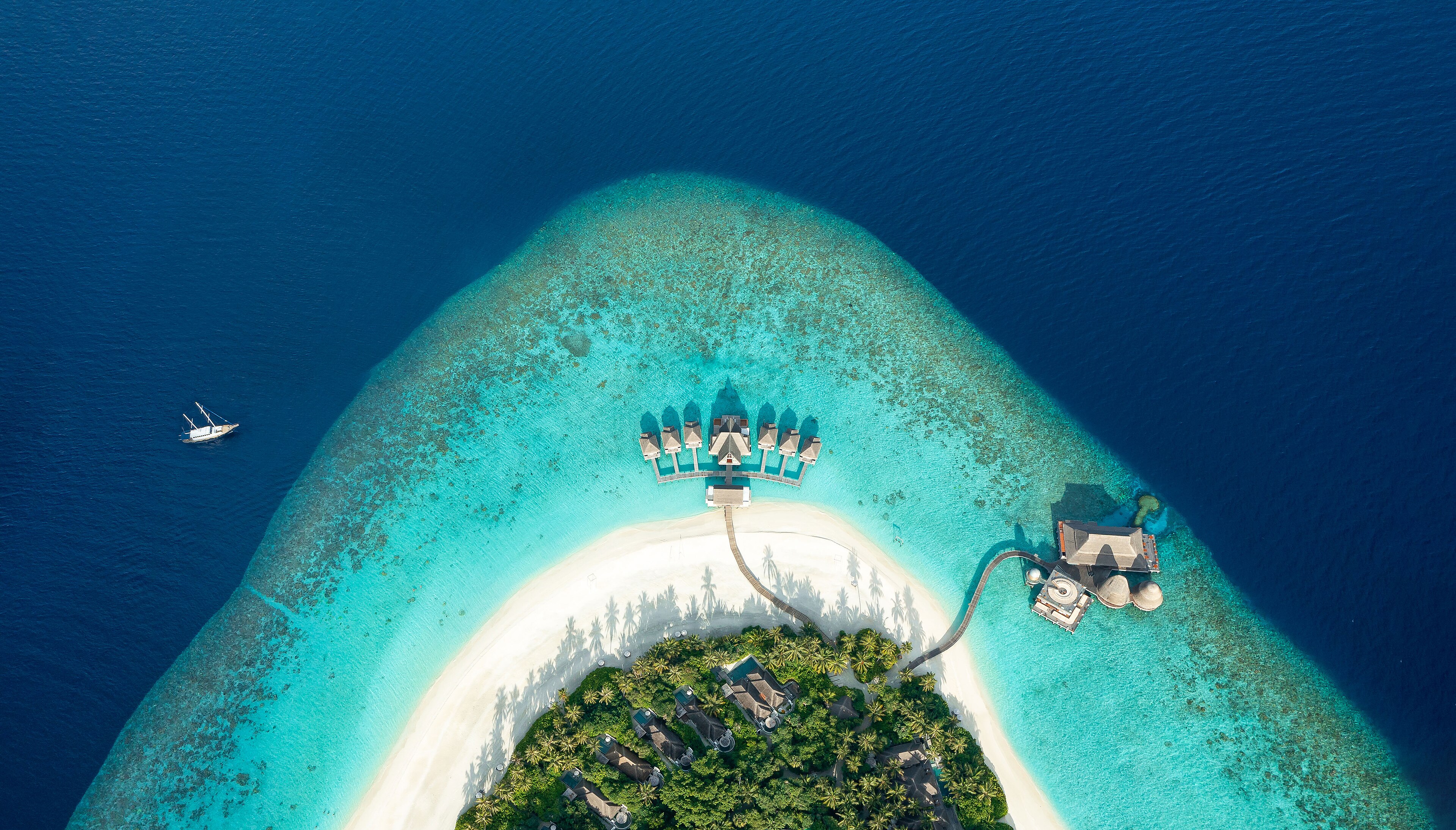 Aerial view of the turquoise lagoon and private island at The Serai Inar